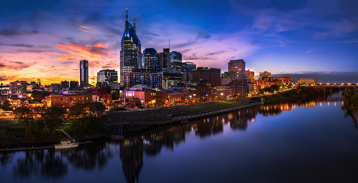 A view of the Nashville skyline across the Cumberland River at night.