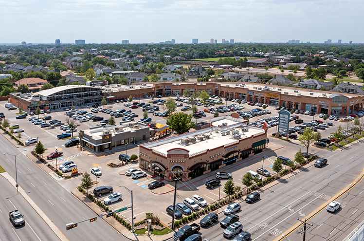 An aerial view of the Preston Oaks center showing a bustling parking lot and adjoining streets.