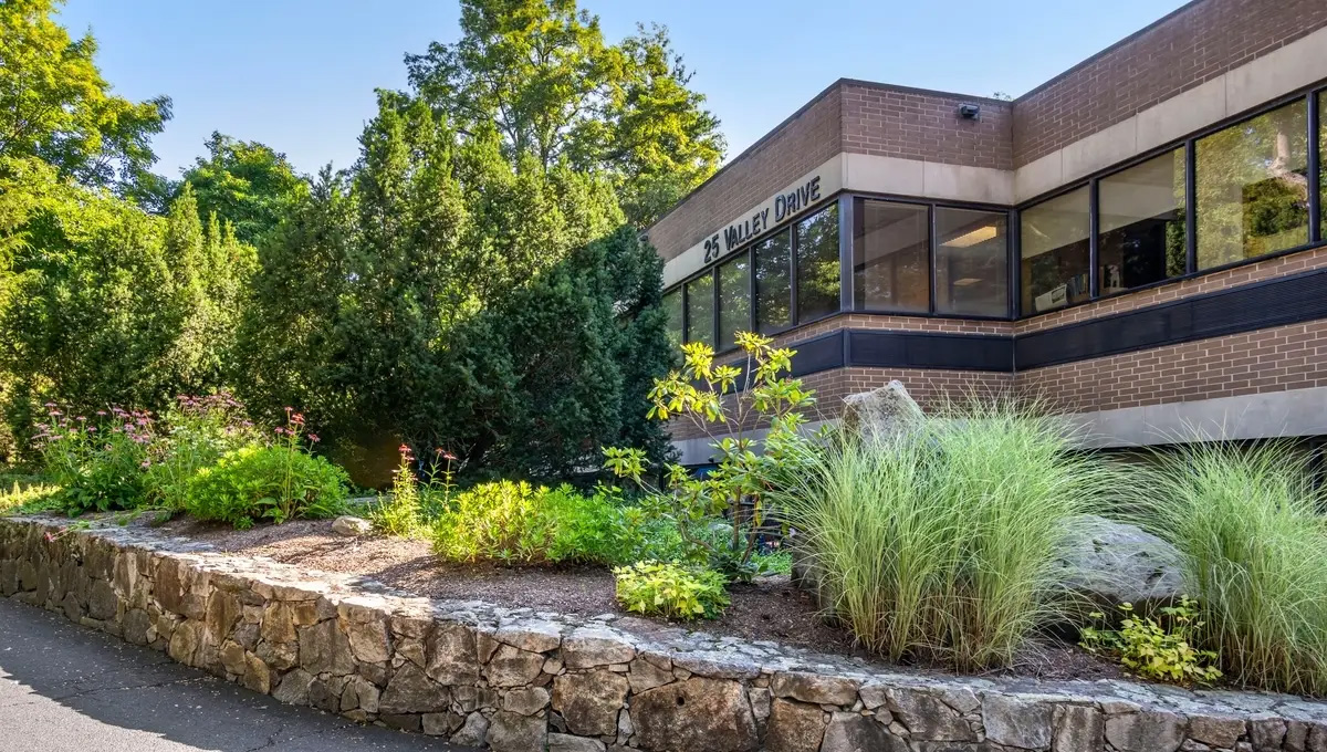 An exterior shot of a small office building surrounded by trees.