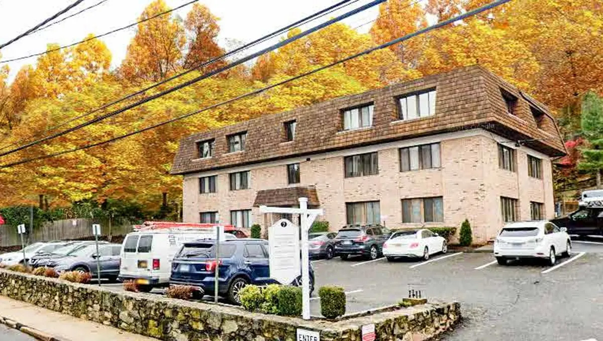 A two story office complex surrounded by autumn foliage