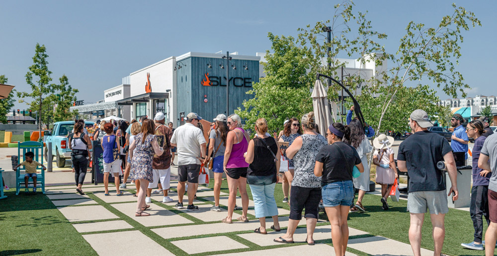 People congregating on the lawn of Mellody Farm in Vernon Hills, Illinois. Slyce Pizza is seen in the background.