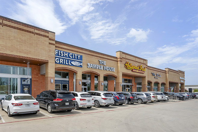 A section of storefronts featuring Fish City Grill, The Sample House, and Hollywood Feed.