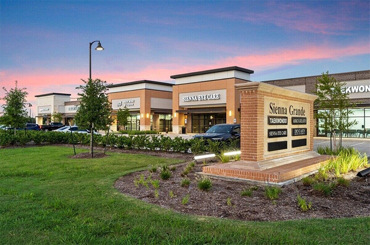 Sienna Grande Shops, featuring local retailers and a monument sign with retailer names.
