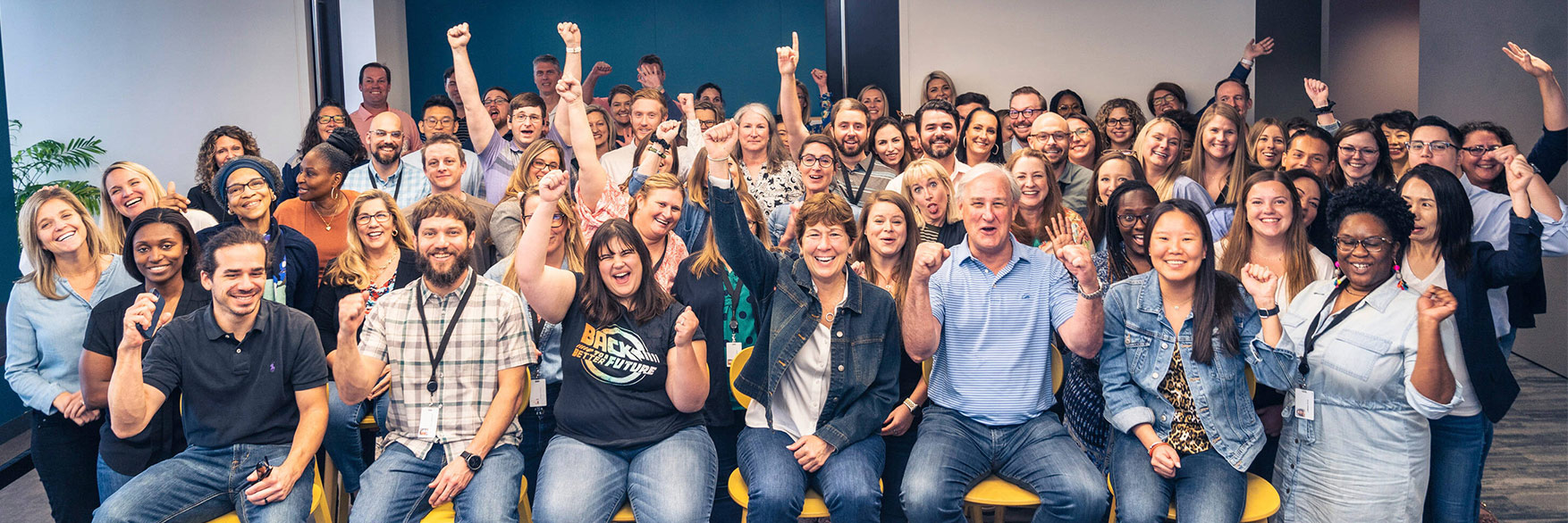 Regency employees cheering and smiling in a big group.